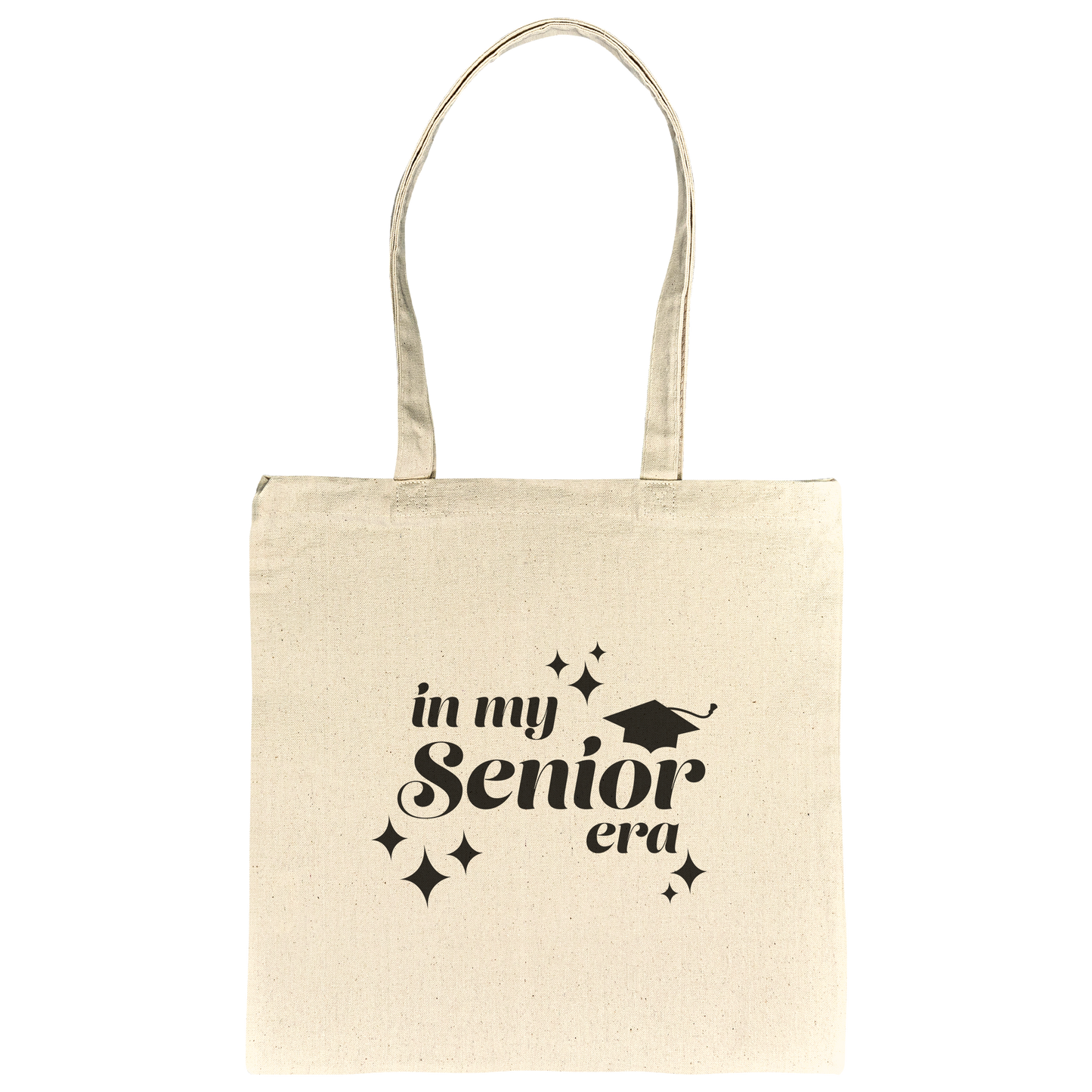 Tan canvas tote bag with the phrase “In My Senior Era” and a graduation cap printed in black ink laying flat
