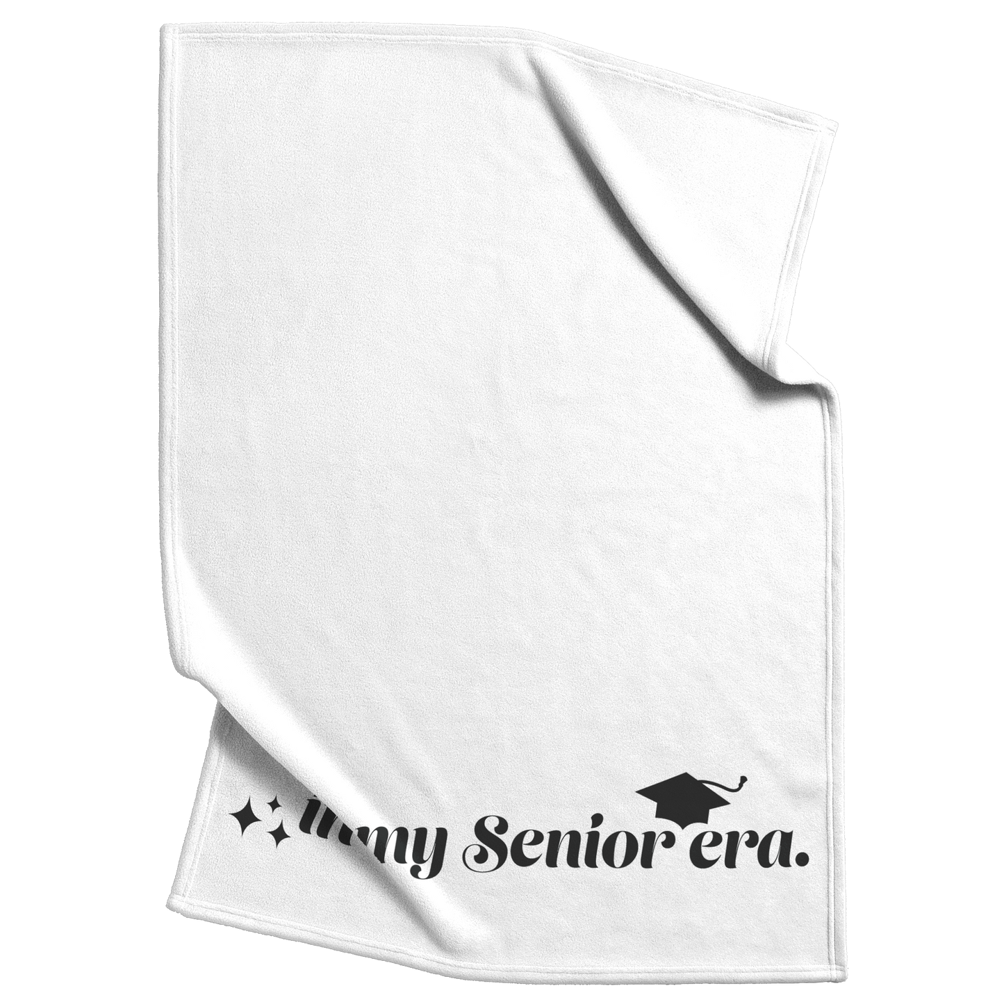 A white fleece blanket with the phrase "In My Senior Era" and a graduation cap in black at the bottom scrunched up in the top right and the bottom left.