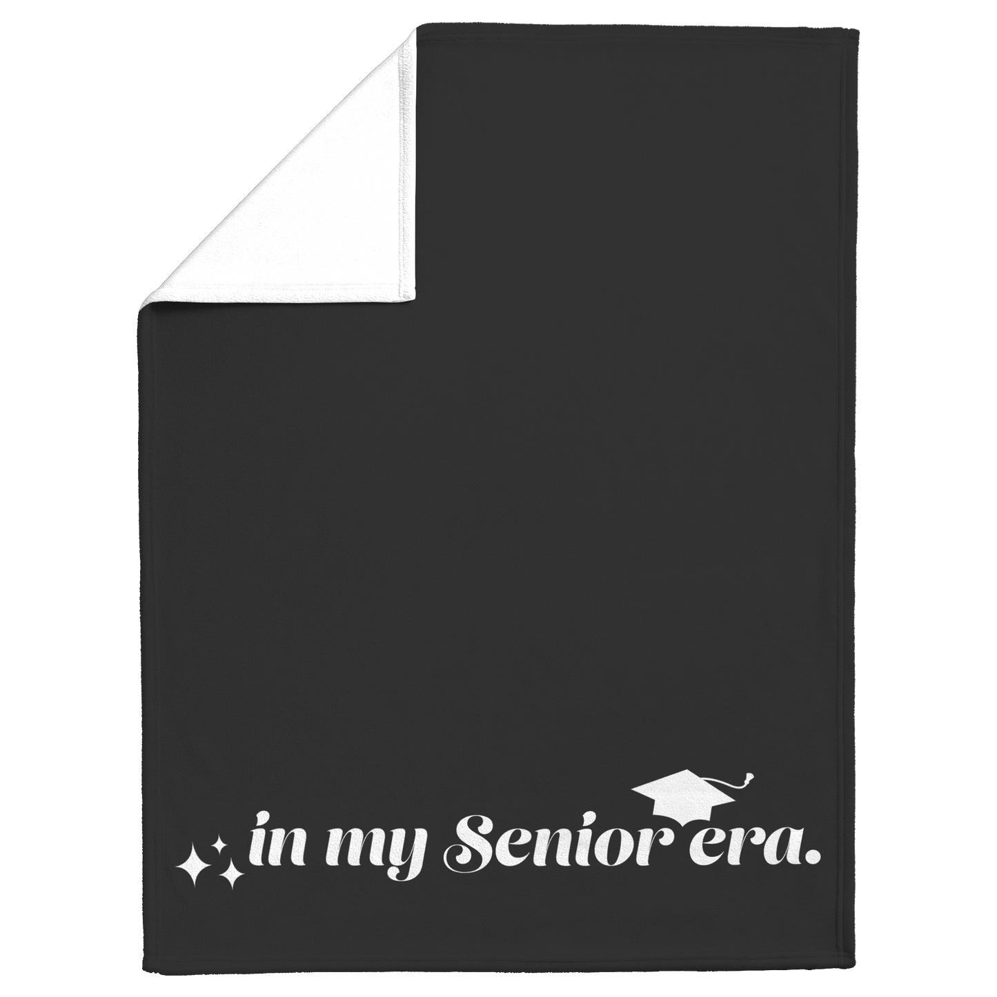 A black fleece blanket with the phrase "In My Senior Era" and a graduation cap in white at the bottom folded down at the top left to show the white back.