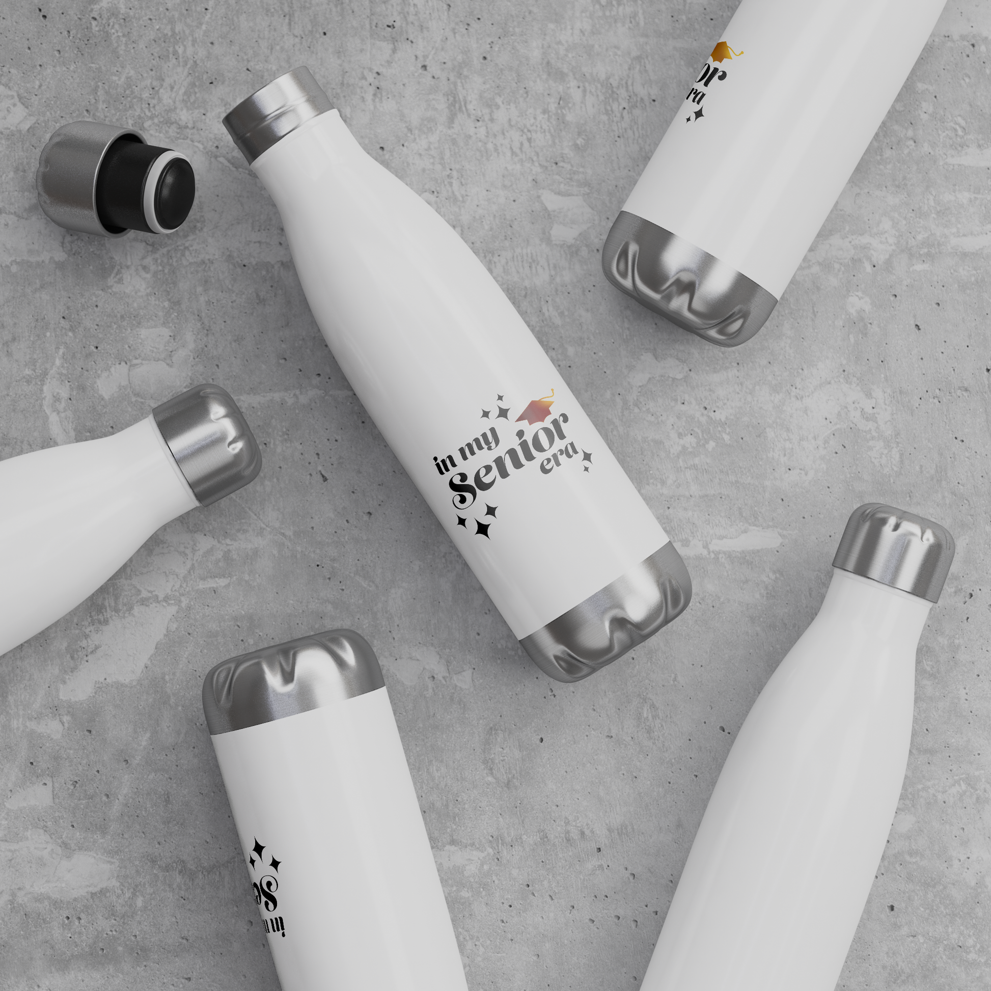 5 white, 20oz water bottles with a silver lid and base laying down scattered on surface. Text in the bottom center of the bottle says "In my Senior Era" in black with a gold graduation cap.